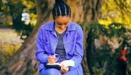 Woman writing a book in a park